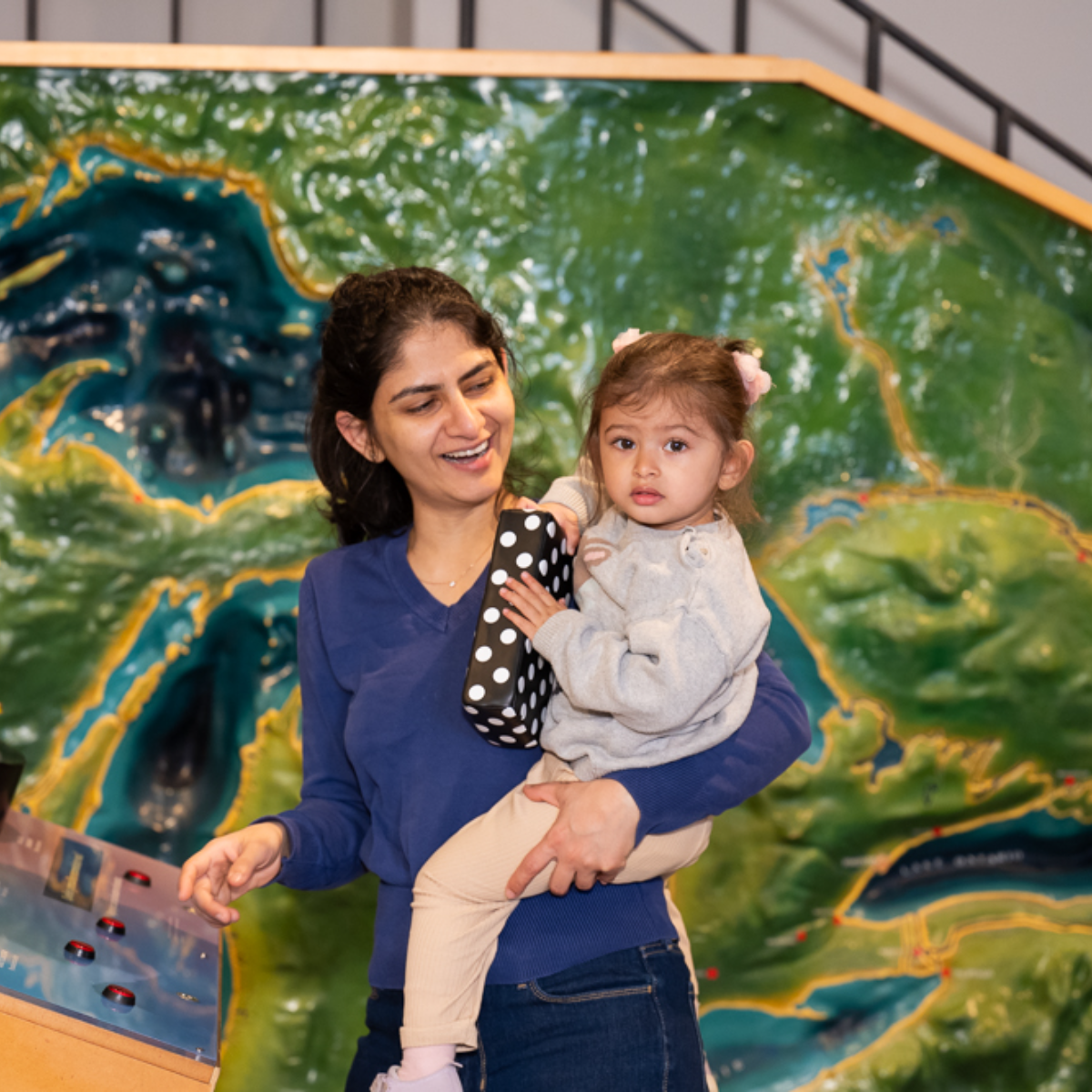 A woman carrying a girl in her arms.