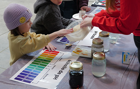 A girl examines a pH science booth.