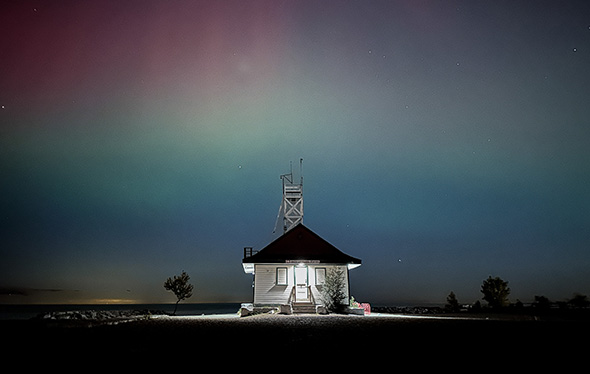Northern Lights behind a beach house.