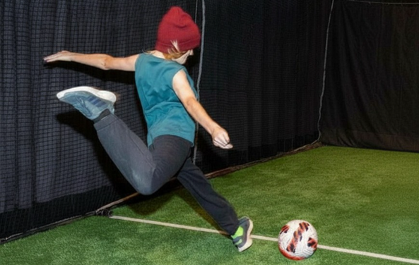 [A girl kicks a soccer ball.][Une fille donne un coup de pied dans un ballon de football.]