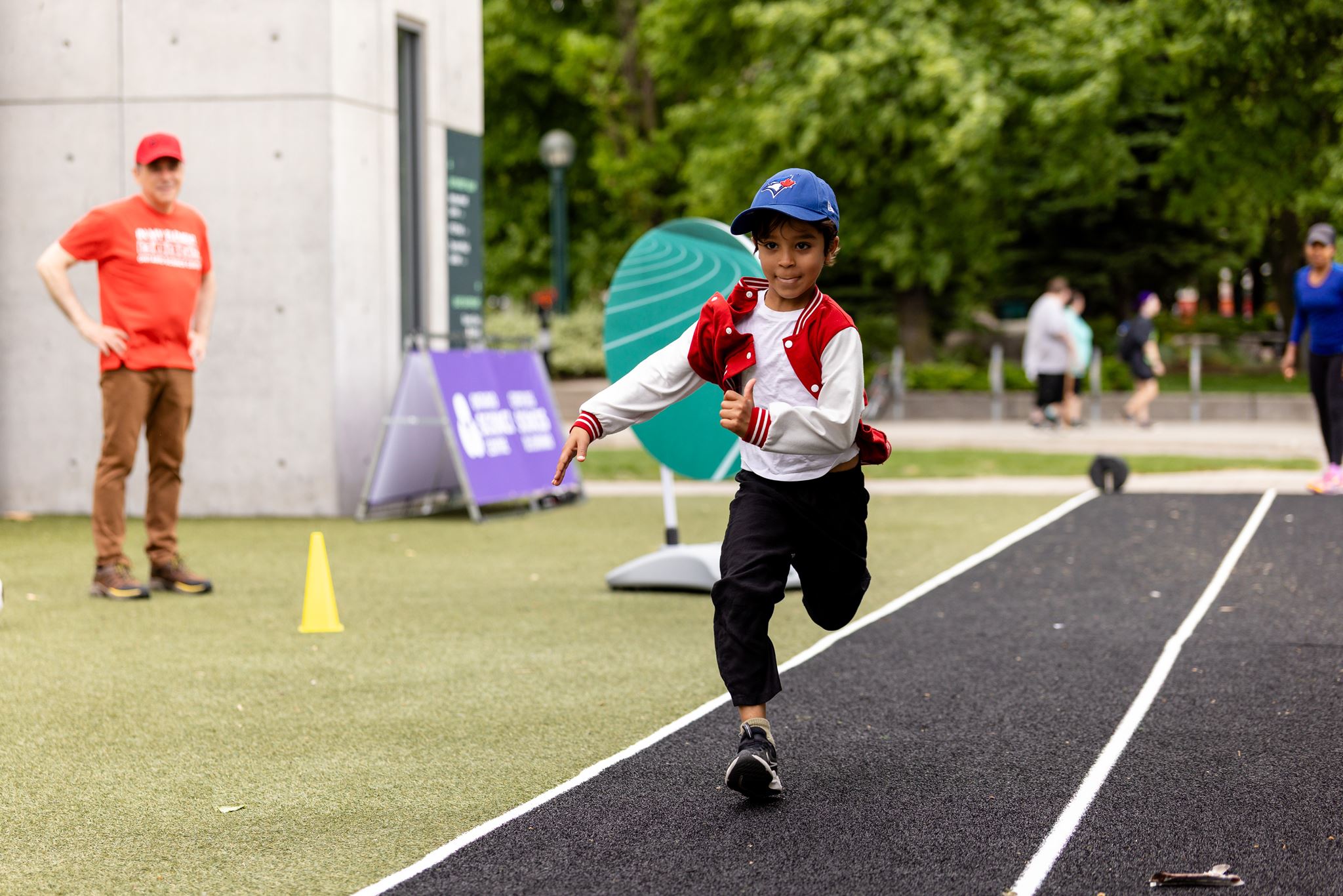 [A boy running on the racing track.][Un garçon court sur la piste de course.]