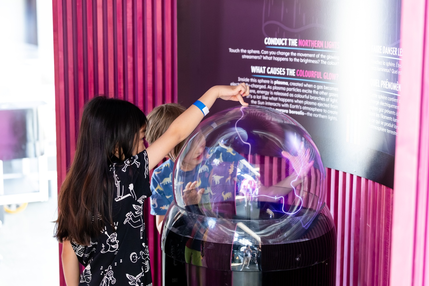 [Two kids playing with the plasma ball.][Deux enfants jouent avec la boule à plasma.]