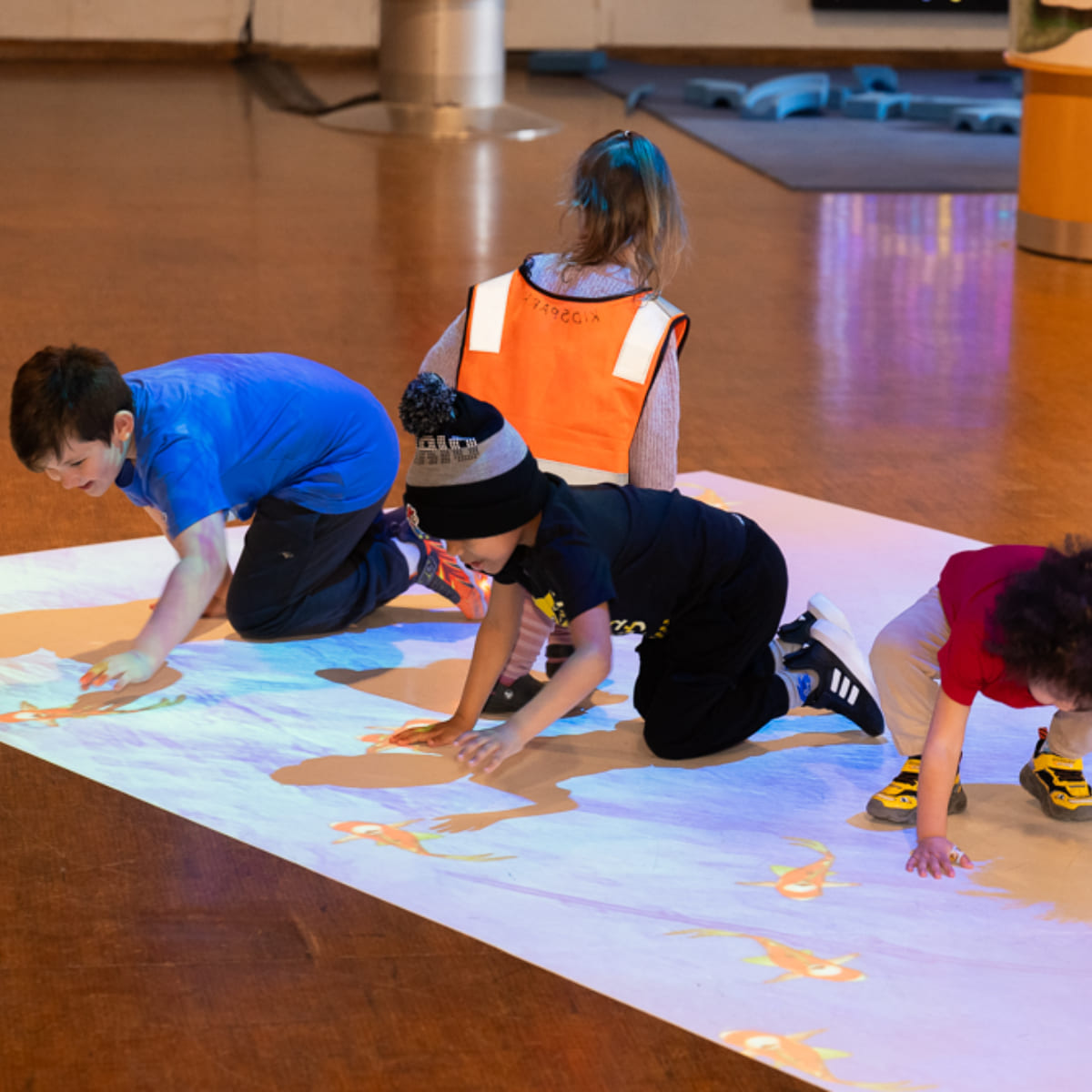 A group of kids playing on the hot zone floor.