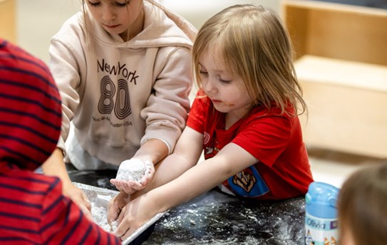 [2 kids play with an experiment.][Deux enfants jouent à une expérience.]