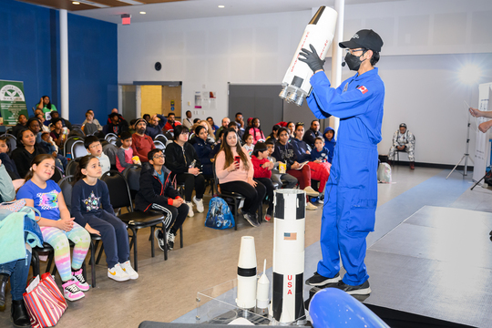 Space researcher teaching kids about spacecrafts.