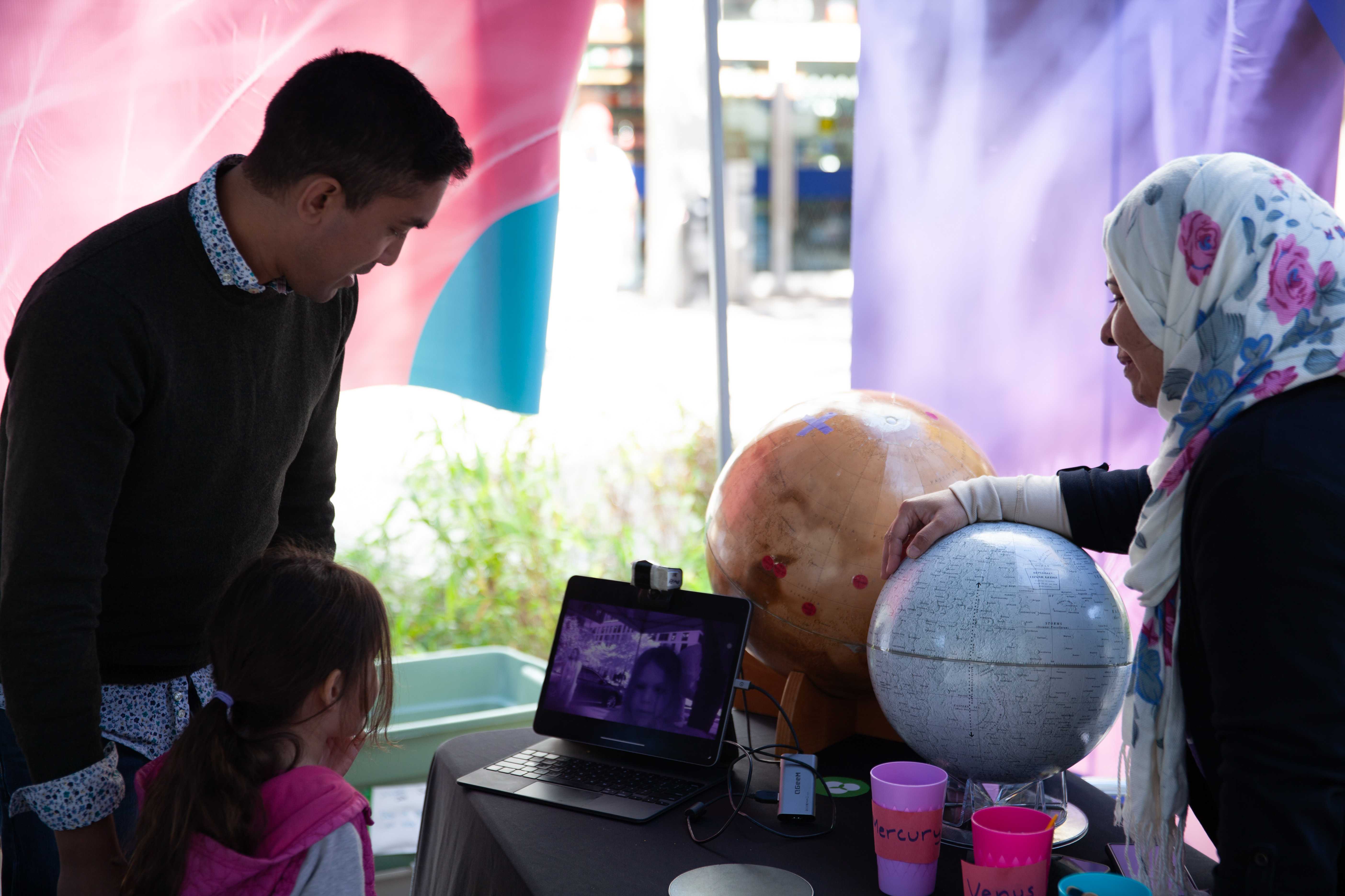 Three people stand at solar themed booth.
